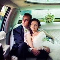 wedding couple in back of limousine